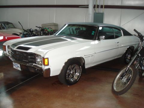 1979 Ford Bronco - A white 1971 Chevrolet Chevelle SS is parked indoors next to motorcycles and another car.