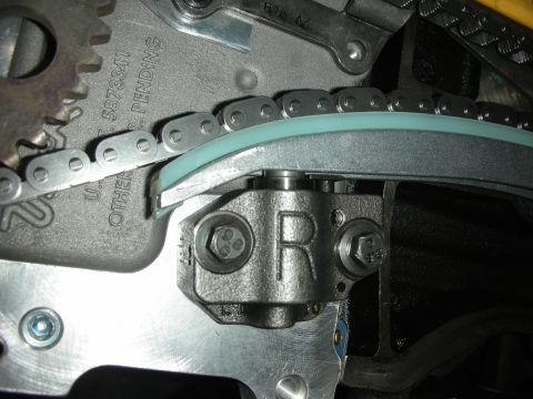1992 Ford Crown Victoria - Close-up view of an engine's timing chain and tensioner mechanism, showing mechanical components and part identification marks.
