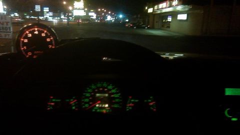 2000 Mercury Grand Marquis - Interior view of a car's dashboard and tachometer at night, with streetlights visible through the windshield.