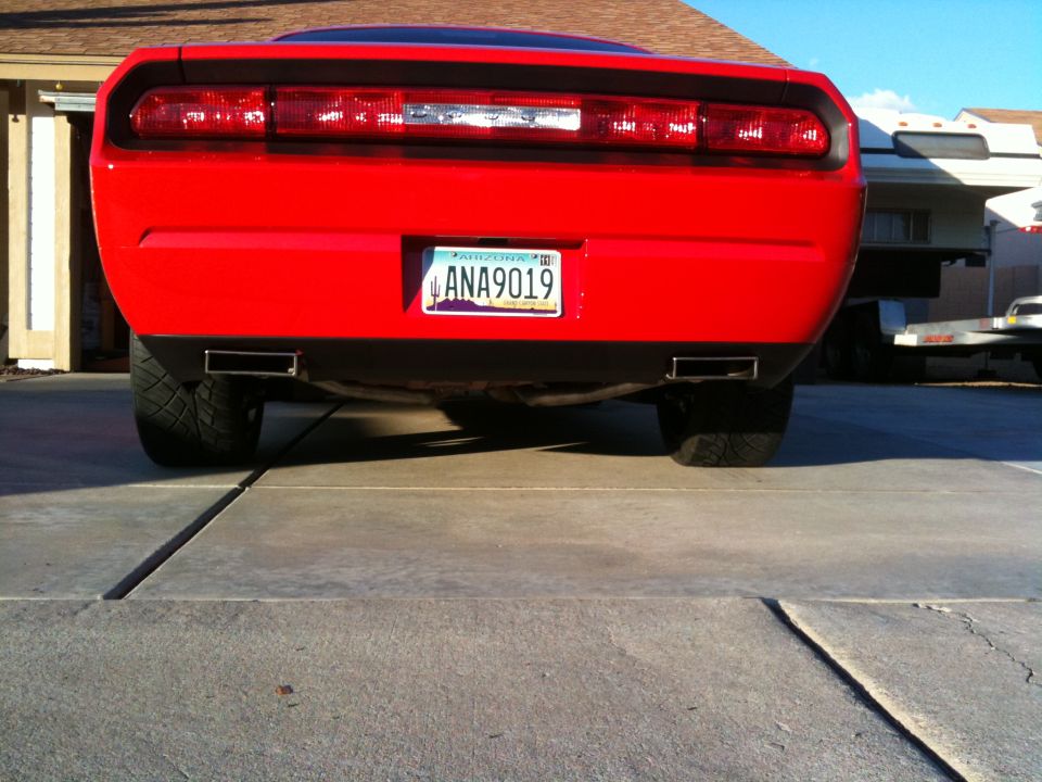 Rear of red coupe with Arizona plate ANA9019 and dual exhaust tips on a driveway