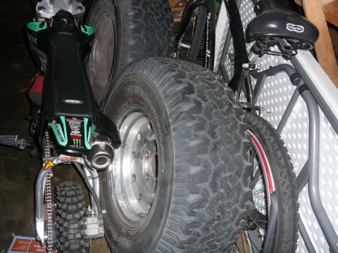 1988 Ford Bronco - Close-up of various vehicle parts including motorcycle seat, exhaust, and large off-road tires.