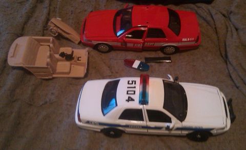2000 Mercury Grand Marquis - Two toy cars, a police car and a fire department car, are shown disassembled.