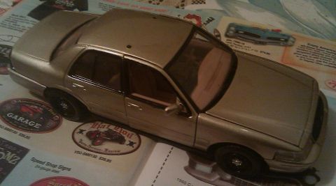 2000 Mercury Grand Marquis - A model car is displayed on pages advertisements for automotive parts and accessories.