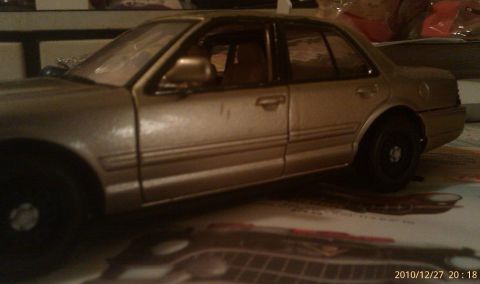 2000 Mercury Grand Marquis - A close-up shot of a gold-colored model car, seen from the side.