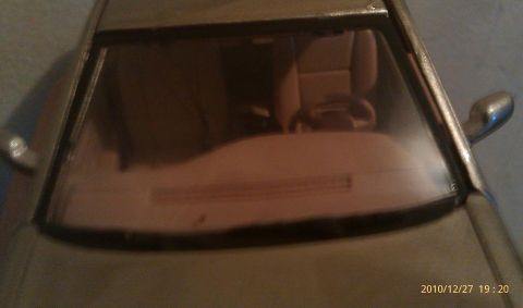 2000 Mercury Grand Marquis - The interior of a toy car is visible through the windshield, including the seats and steering wheel.