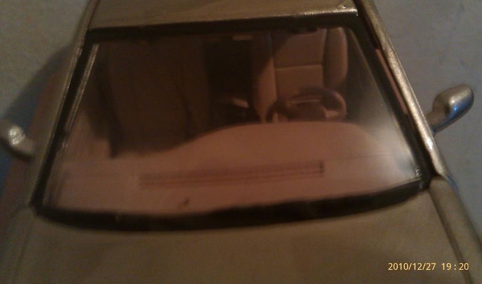 Close-up of a toy car's windshield showing the interior with seats and steering wheel