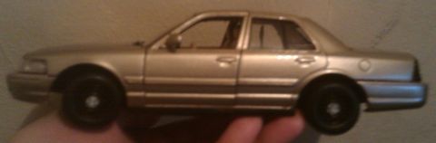 2000 Mercury Grand Marquis - A gold toy model of a 2000 Mercury Grand Marquis is shown from the side.