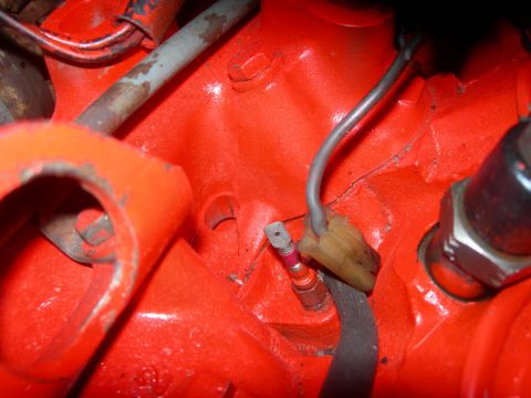 1984 Ford Bronco - Close-up view of an engine block with a sensor and wiring attached.