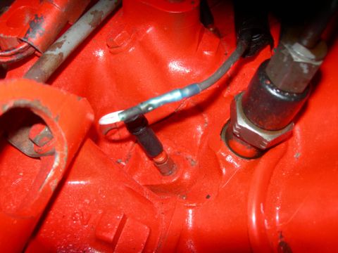 1984 Ford Bronco - Close-up of an engine component with a sensor and electrical connection visible.