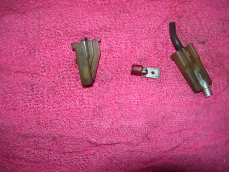 Two electrical connectors and a wire terminal on a pink cloth
