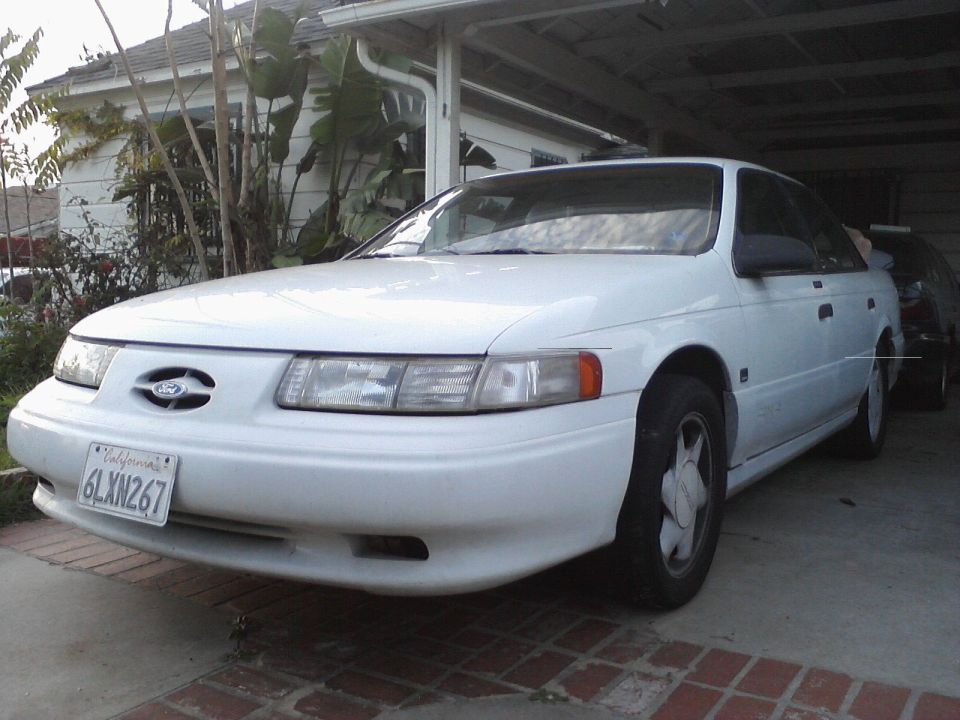 White 1992 Ford Taurus parked in a driveway, front 3/4 view. California license plate 6LXN267 is visible