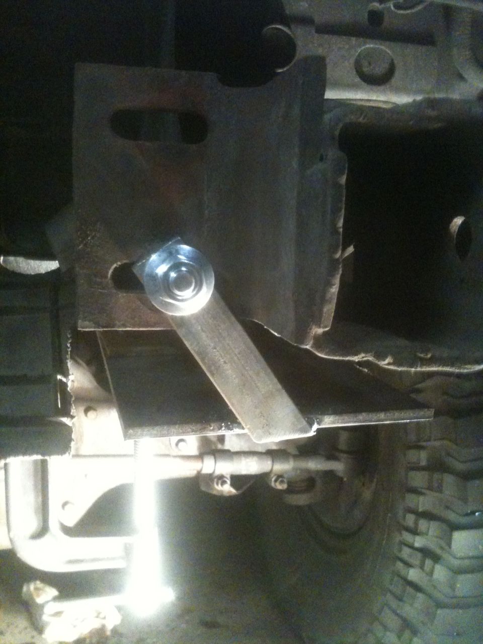 Custom trailer hitch receiver bracket with a bolt and metal strap