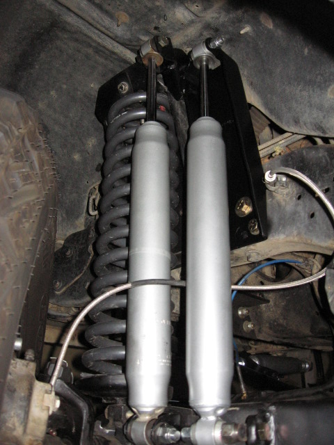1995 Ford Bronco - Close-up view of the front suspension system, showing dual shocks and coil springs.