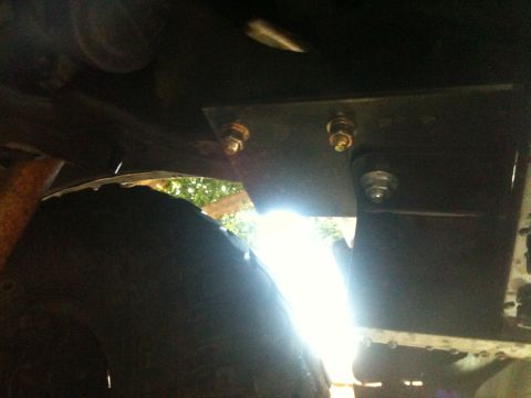 1996 Ford Bronco - Close-up view of a receiver hitch bracket and tire on a vehicle's undercarriage.