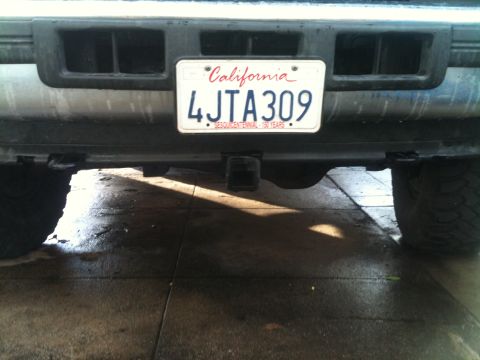 1996 Ford Bronco - The rear of a vehicle shows a California license plate and a trailer hitch.
