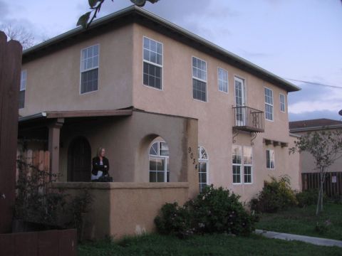 1968 Ford Mustang - A tan stucco building with multiple windows and a balcony is shown with a person standing on the porch.