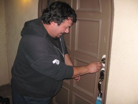 1968 Ford Mustang - A man is seen using a key to unlock a brown door.