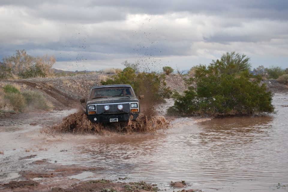 Jeep Cherokee XJ driving through mud and splashing water
