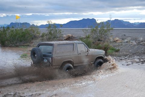 1982 Ford Bronco - This 1982 Ford Bronco navigates a muddy off-road trail, kicking up water as it goes.