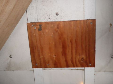 1991 Ford Bronco - A wooden panel is attached to a wall with screws, showing a section of a Supermotors.net watermark.