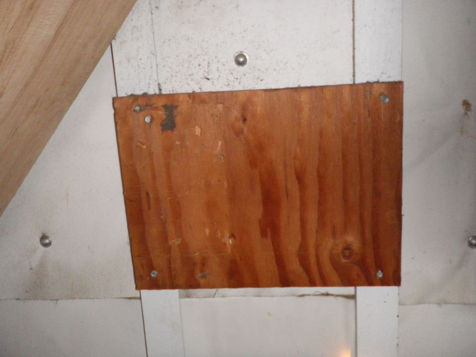 plywood panel screwed to a wall with some white paneling