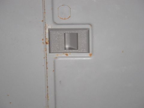 1991 Ford Bronco - Close-up of interior door handle trim showing signs of rust around the edges.