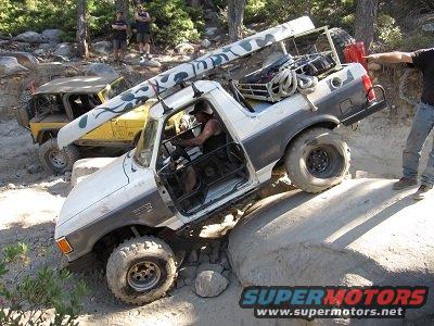 1991 Ford Bronco - This modified Bronco navigates a challenging rocky trail with a canoe secured to its roof rack.