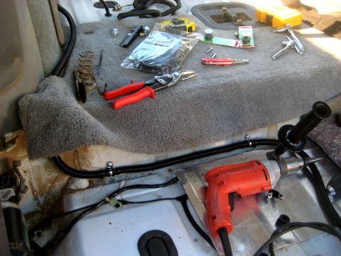 1996 Ford Bronco - Tools are laid out on the carpeted floor of a vehicle's interior, suggesting ongoing work.