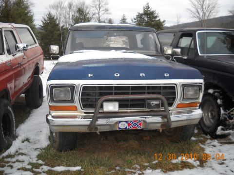 1982 Ford Bronco - A blue Ford Bronco is parked outside in the snow, with other vehicles nearby.