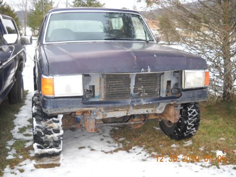 1982 Ford Bronco - This Ford truck, likely from the early 1980s, is missing its grille and has been fitted with off-road tires.