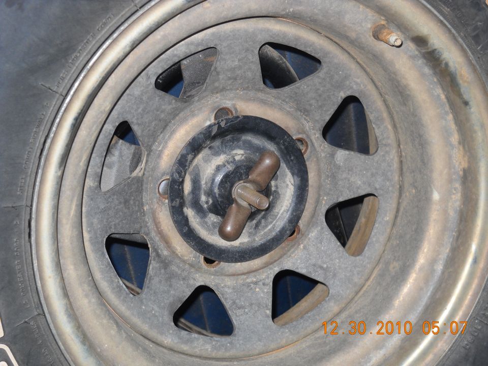 Close-up of a wheel hub with a wingnut and a tire