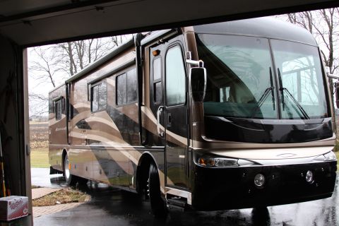 2003 Ford F-350 - A motorhome is parked inside a garage with the door open.