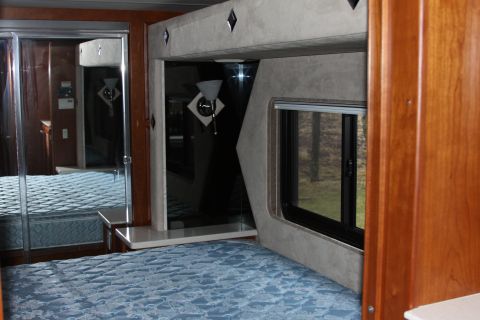 2003 Ford F-350 - Interior view of an RV bedroom, a bed and mirrored closet doors.