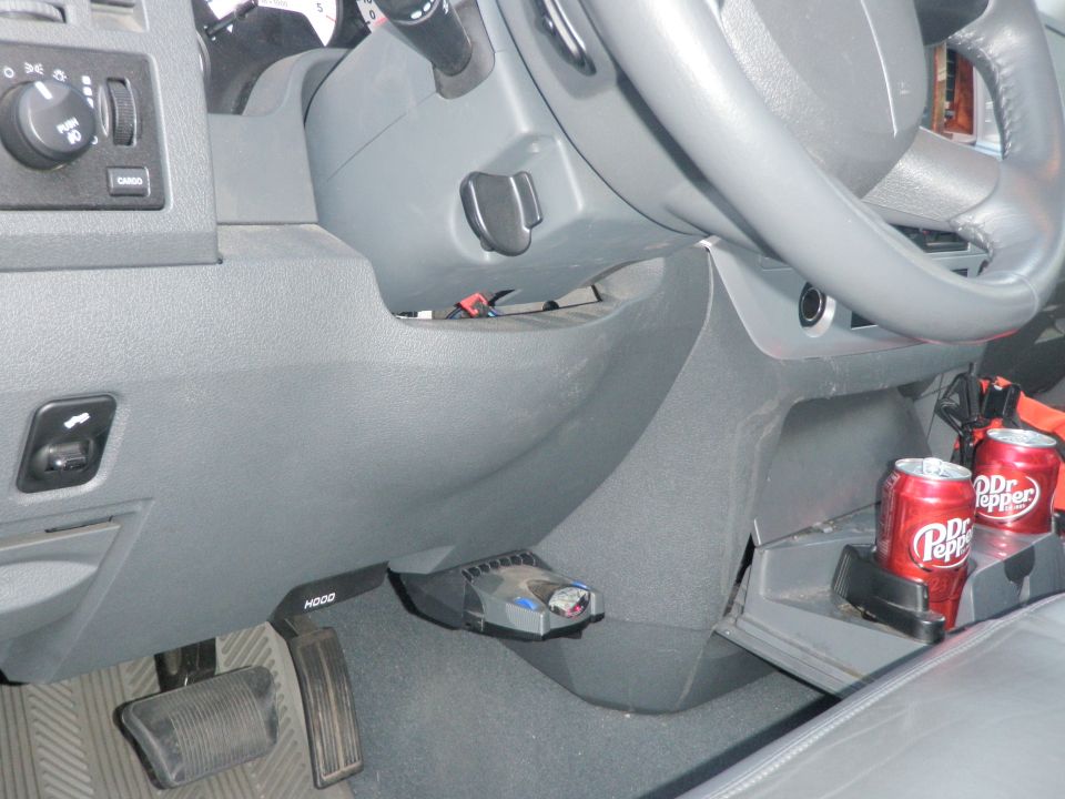 Vehicle interior with brake controller and two Dr. Pepper cans in the cup holder