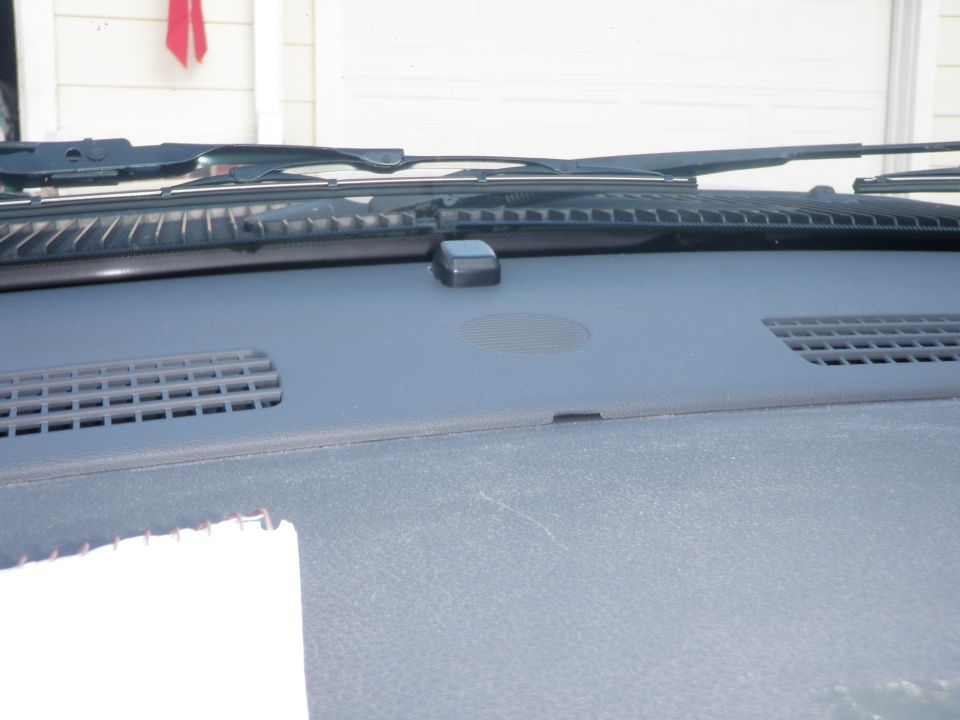 Dashboard with windshield wipers and vents visible. A small black device is mounted on the dash