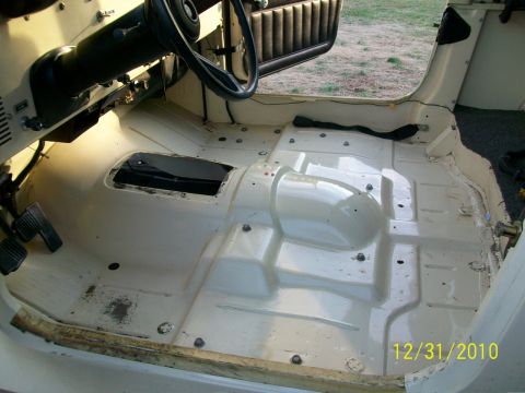 1986 Jeep Wagoneer - Interior floor of a 1986 Jeep Wagoneer stripped for restoration, showing the transmission tunnel and pedals.