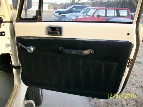 1986 Jeep Wagoneer - Close-up of the interior door panel of a vehicle, with other cars visible through the window.
