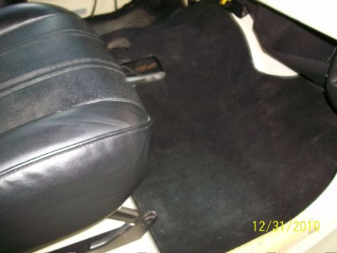 1986 Jeep Wagoneer - Vehicle interior showing a black seat and carpeted floor with a date stamp.