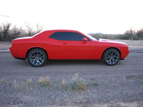 2010 Dodge Challenger - Red Dodge Challenger parked on a dirt road with dry brush and distant hills.