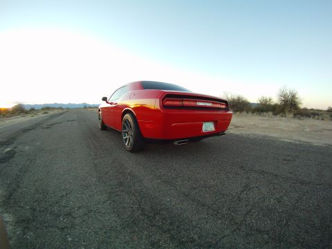 2010 Dodge Challenger - Rear view of a red Dodge Challenger on a desolate desert road at sunset.