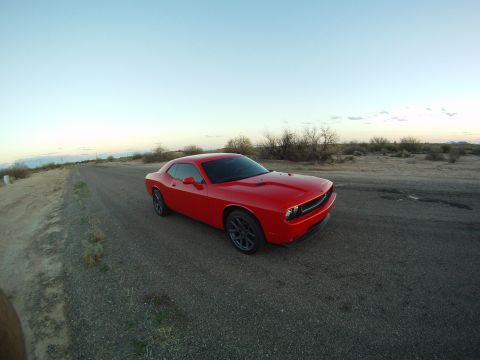 2010 Dodge Challenger - Red Dodge Challenger parked on a dirt road during sunset.