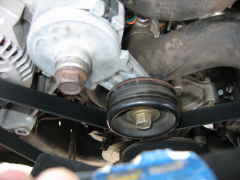 1992 Ford Bronco - Engine bay view of the serpentine belt and pulley assembly, focusing on the alternator and tensioner components.