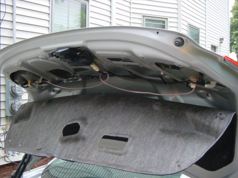 2003 Mazda 6 - The interior of a car's trunk is visible with wiring and insulation removed.