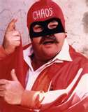 1989 Ford Bronco - A man in a red costume and mask, with the word 'CHAOS' on his cap, gestures towards the camera.