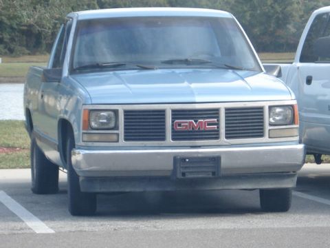1979 Chevrolet C/K Pickup - A light blue pickup truck is parked in a lot, with another vehicle partially visible to its right.