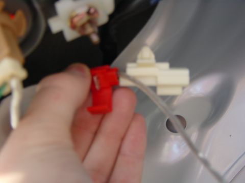 2003 Mazda 6 - A hand is shown connecting a red electrical connector to a white clip, likely part of a vehicle's wiring system.