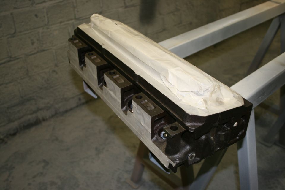 Engine block on stand, partially covered with paper