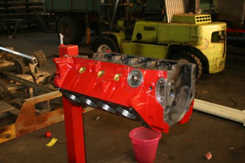 1973 Ford Ranchero - V8 engine block on a stand in a workshop, with a forklift visible behind it.