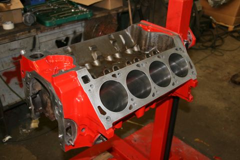 1973 Ford Ranchero - A red engine block is mounted on a stand in a garage setting, with tools visible in the background.