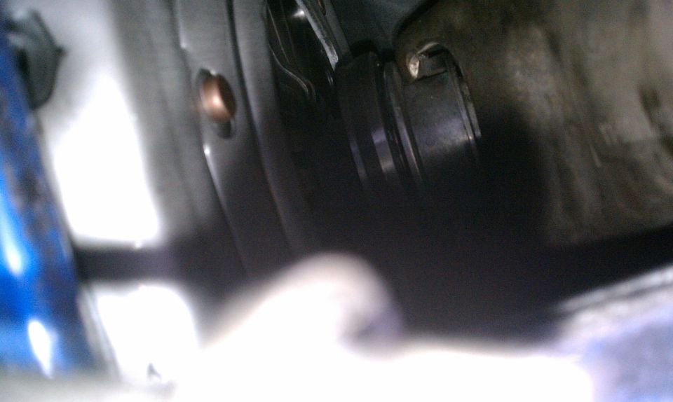 Close-up of a dark mechanical part with a copper bolt